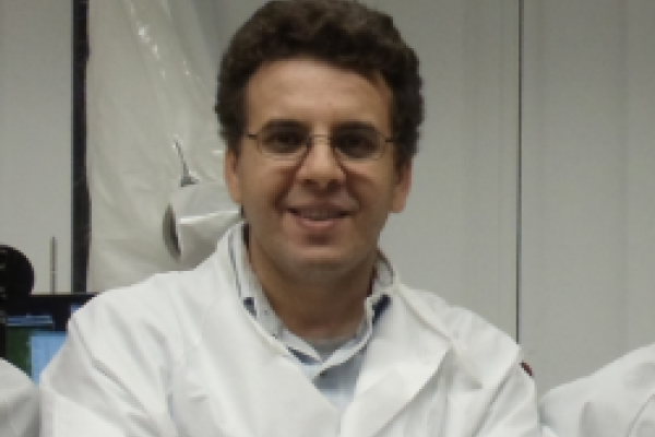 A close-up of Dr. Kramer Akli in a white lab coat.