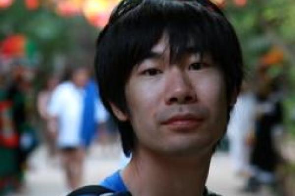 A close-up of Weiran Li with a blurred background of people walking.