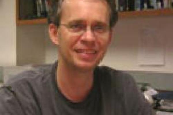 A picture of Dmitry Matyushov with bookshelves in the background.