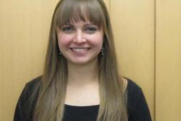 Rebecca Reesman smiling with wood panel background