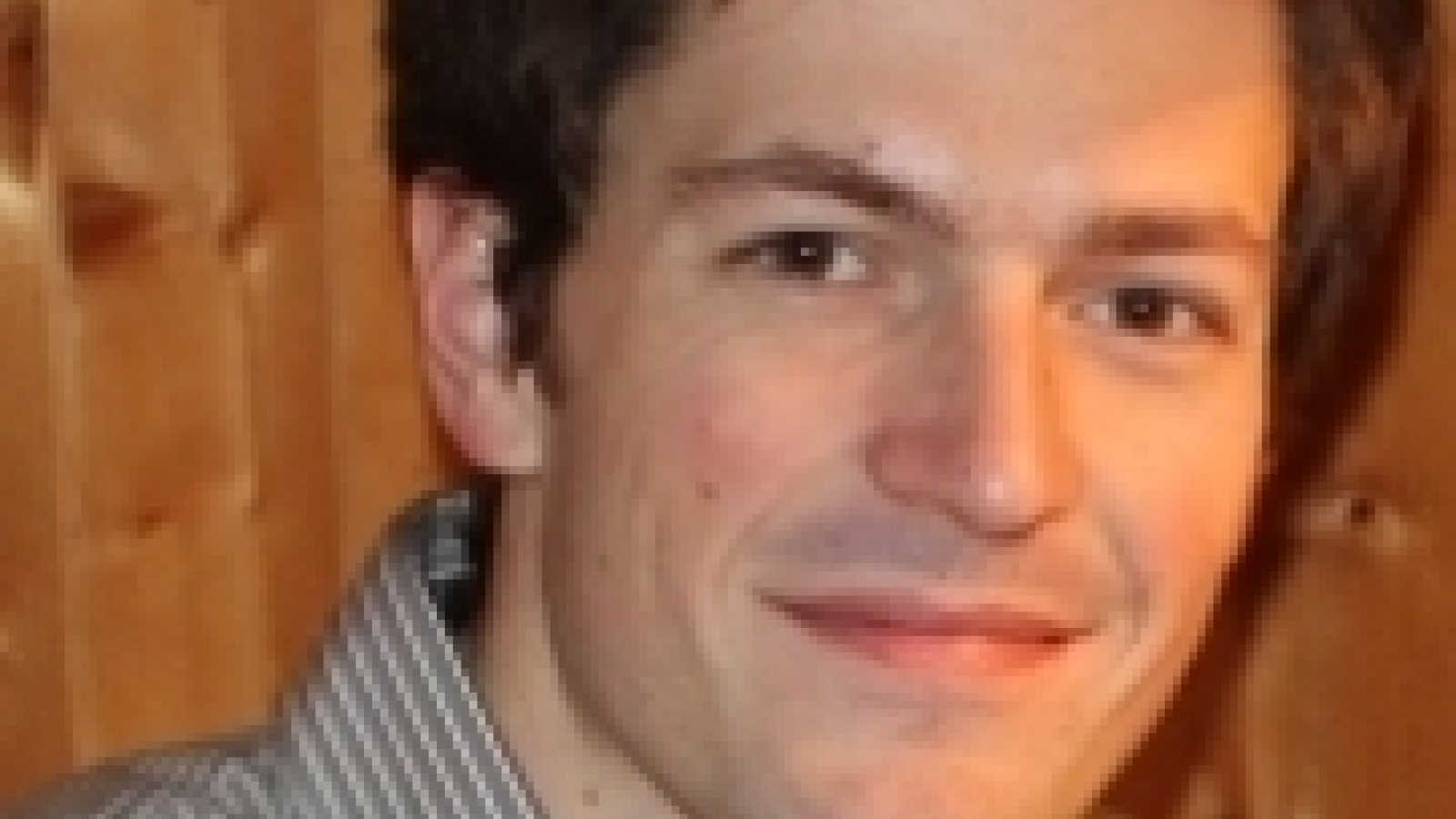 A close-up of Stefan Floerchinger with wood as the background.