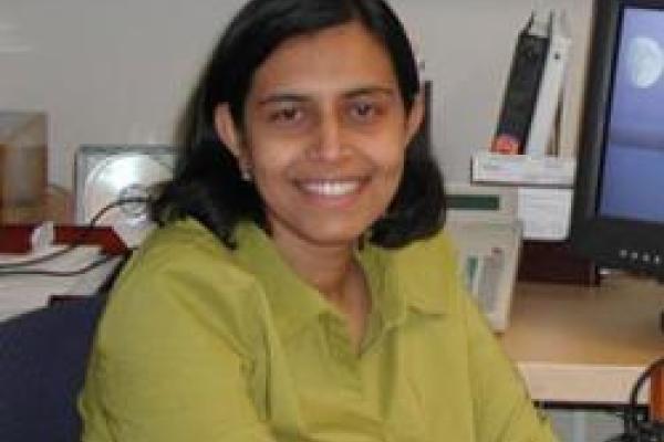 A picture of Vidya Madhavan sitting at a desk.