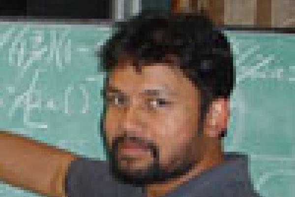 Prof. Chowdhury writing on a large chalkboard