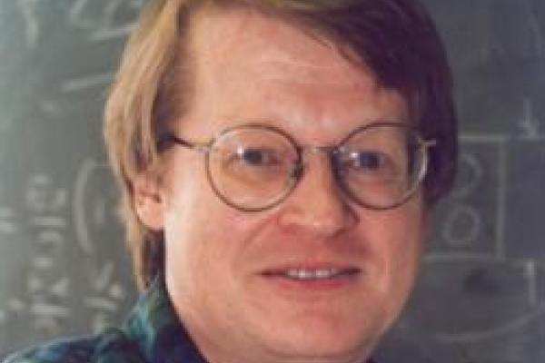 Michael Downer in front of a chalkboard