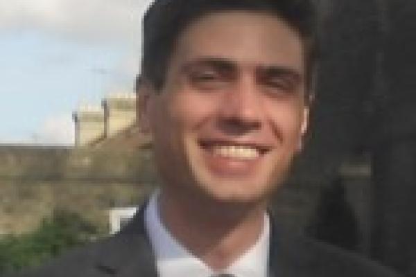 Antonio Boveia in suit with blurry structure behind him