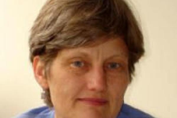 A close-up of Lisbeth Gronlund with a beige background.