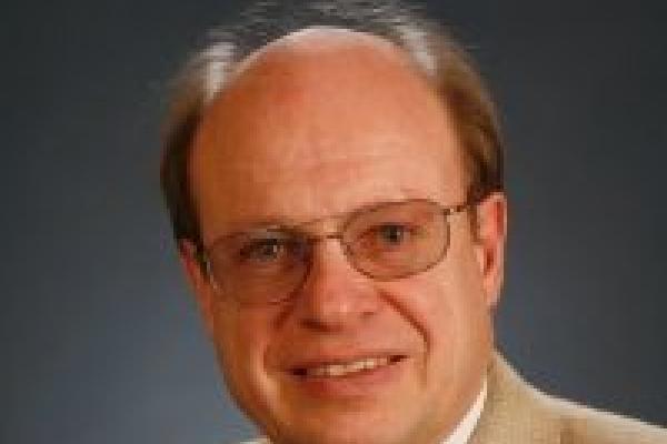 A headshot of Ulrich Heinz with a grey background.