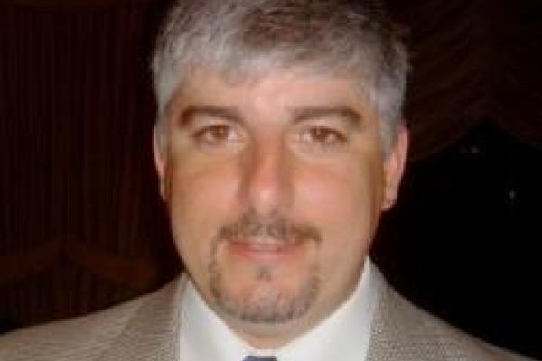 Chris Hill in suit with black background