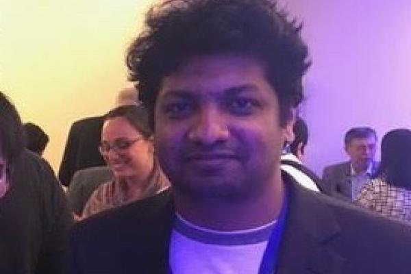 Hiran Wijesinghe in purple lighting at conference