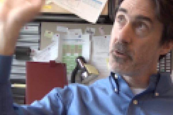 Mike Lisa sitting at his desk and gesturing broadly