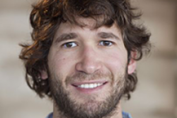 Daniel Holz smiling with brown background