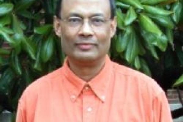 Sankar Das Sarma in front of leafy plants
