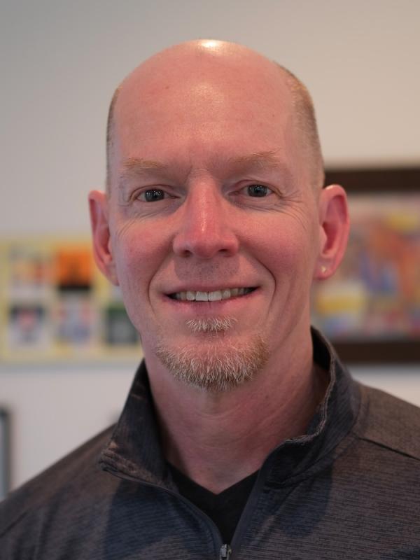 Richard Hughes smiling with blurred background