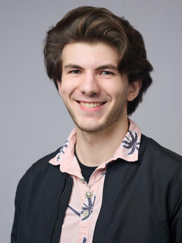 Reilly smiling in front of a grey background