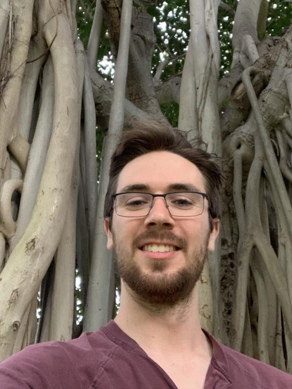 A picture of Ethan Doerstling in front of a banyan tree in Hawai'i