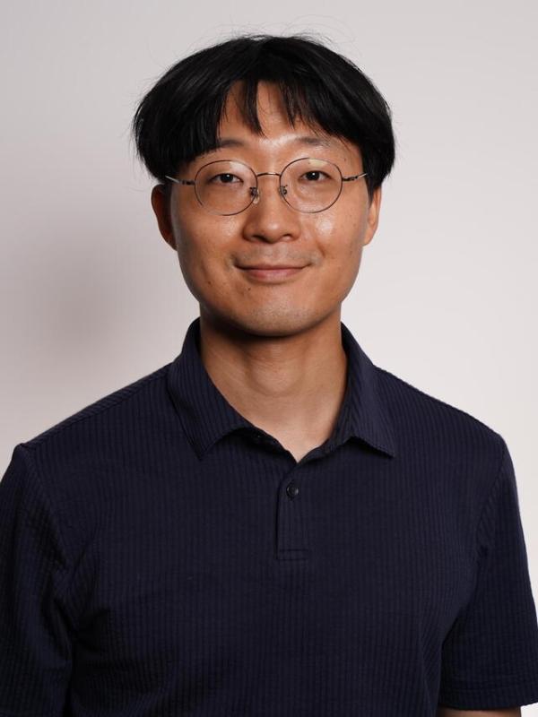 Close up of Youngseok smiling with a neutral background