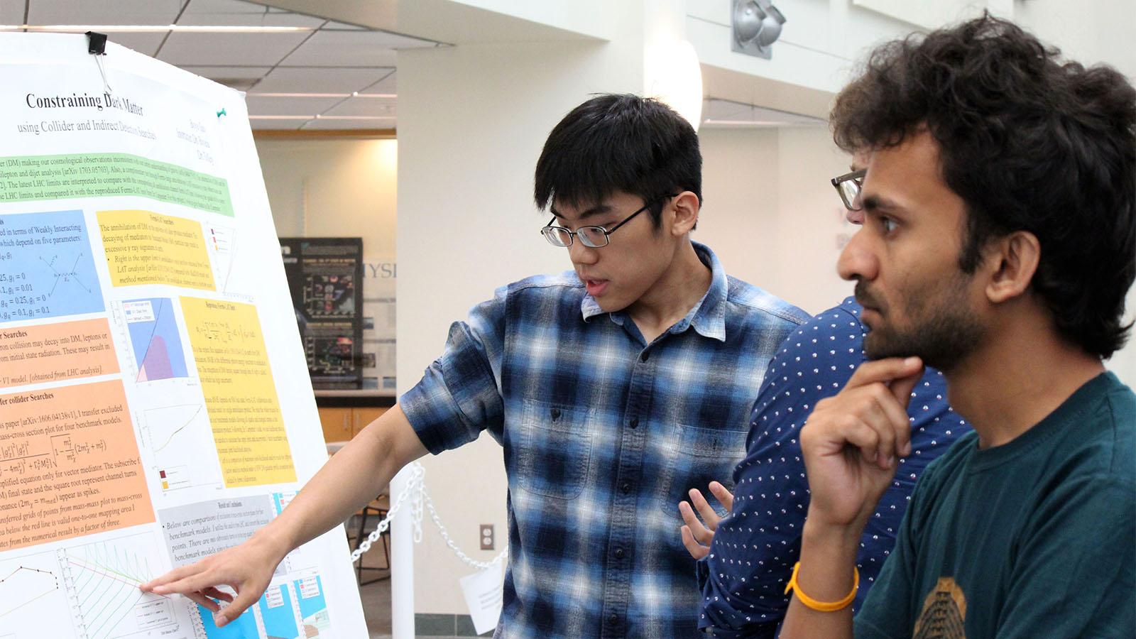student presenting his research at a poster session