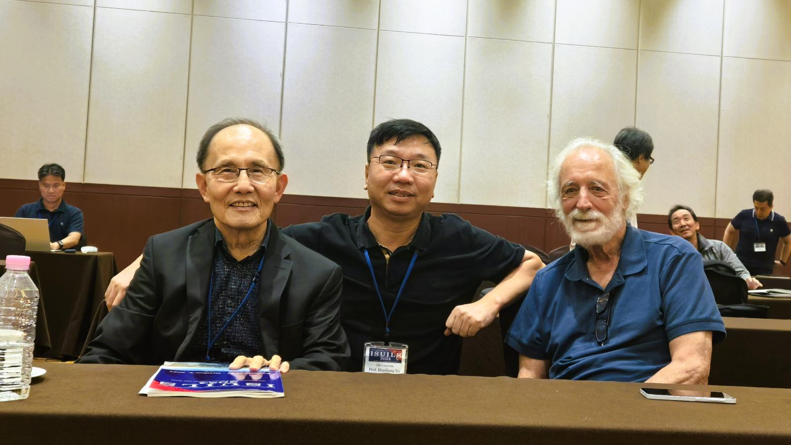 Pierre seated with two ISUILS group members