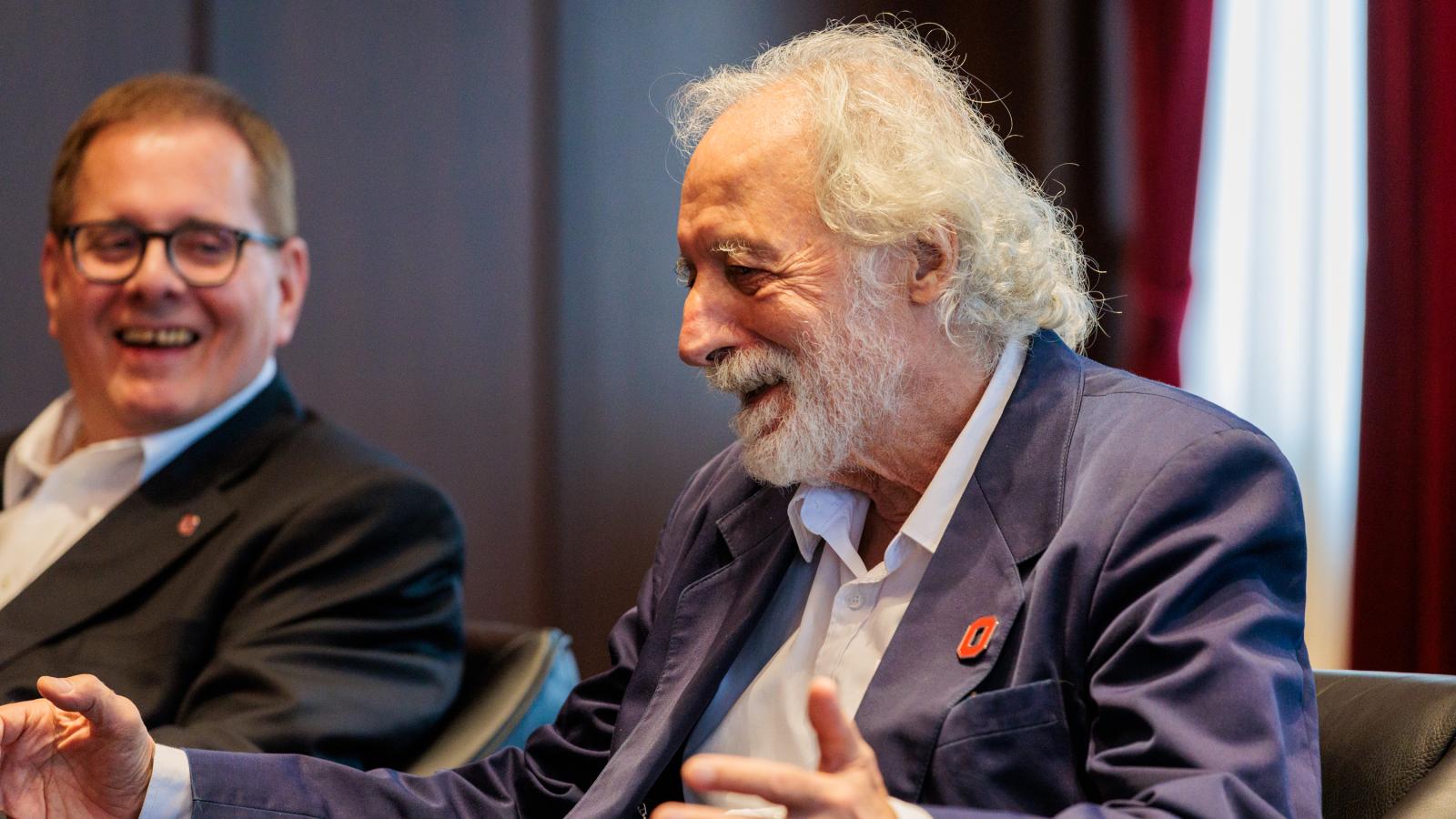 Lou DiMauro and Pierre Agostini smiling and laughing as Pierre speaks