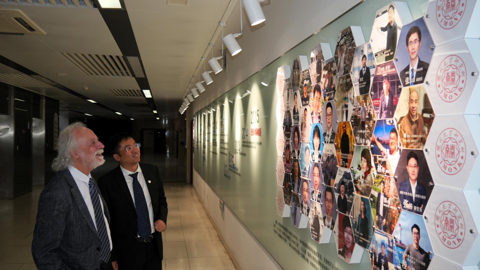 Pierre admiring a display on a wall of the university